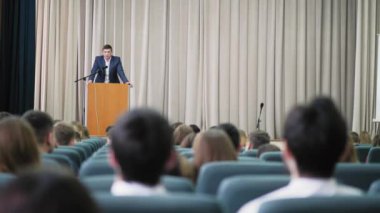 Erkek spiker bir seminer salonunda yürütmektedir
