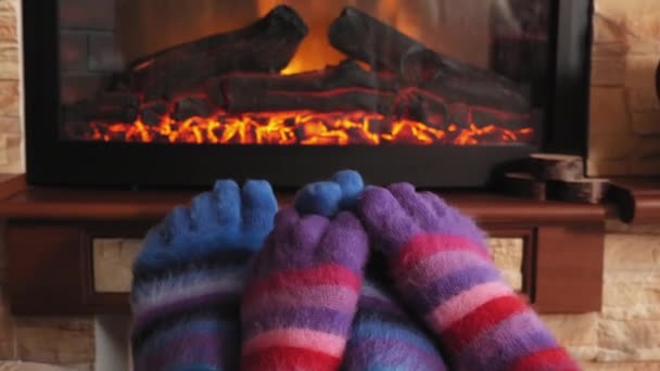 Couple warming feet by fireplace at home — Stock Video