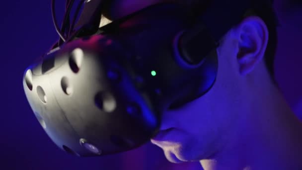 Young man in head-mounted display looks around, virtual reality — Stock Video