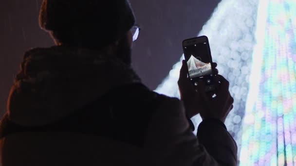Вид Сзади Бородатый Мужчина Фотографирует Сцену Рождественском Рынке Смартфоне — стоковое видео