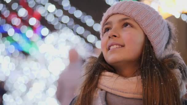一个女孩站在广场上抬头看着一棵圣诞树 特写视频 — 图库视频影像