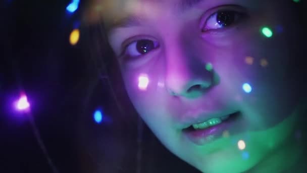 Close-up rosto de uma menina através de luzes luminosas — Vídeo de Stock