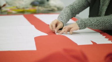 Kadın tasarımcı gelecekteki elbise bir şablon oluşturur. Tebeşirle ayrıntıları çiziyor. Ağır çekim vurdu