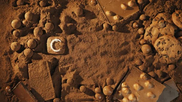 メッセージを停止動きココア チョコレート クッキーのバーで ココア パウダーの背景にナッツ 文字のクッキー 平面図です カメラが単語にズームインします — ストック動画