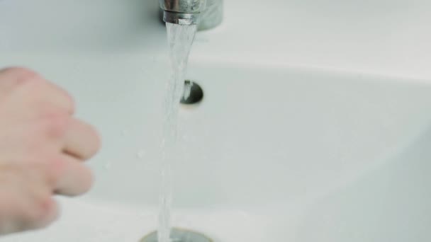 A man washes his hands under the faucet in the bathroom. — Stock Video