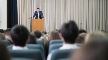 Erkek spiker bir seminer salonunda yürütmektedir