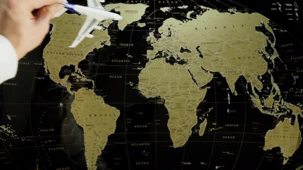 Osobní letadlo hračka v lidské ruce přistane na mapě světa