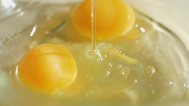 Surowe jajko wpada w misce szkła na tabeli zwolnionym tempie — Wideo stockowe