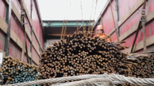 Arbetstagare med hjälp av en kran lastar en bunt av stålstänger — Stockvideo