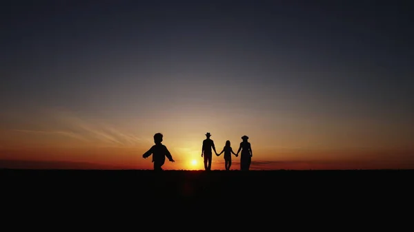 Silhouette à mouvement lent au coucher du soleil marche en famille heureuse — Photo