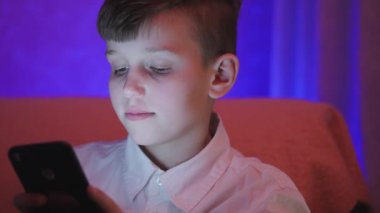 Genç çocuk bilgisayar oyunu kapalı smartphone ile oynamak