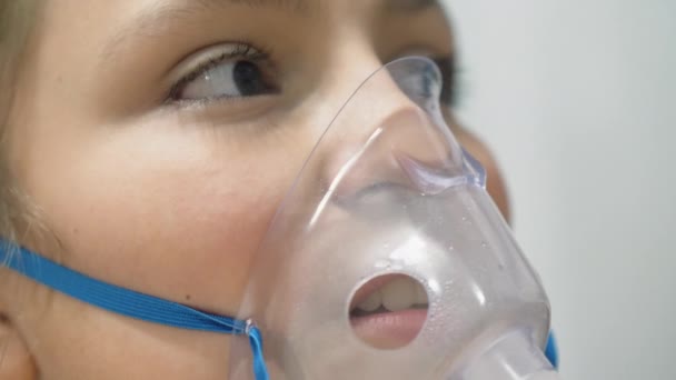 Лицо подростка, вдыхающее через маску ингалятора — стоковое видео