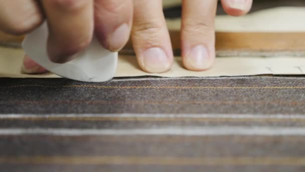 Manos de mujer haciendo marcas de tiza en tela de traje marrón — Vídeos de Stock