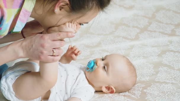 Baby boy lying on the bed, looking at mother — Stock Video