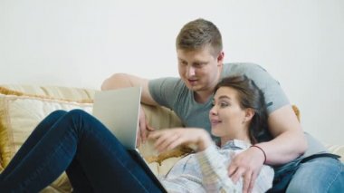 Genç çift dizüstü bilgisayarla ailesiyle görüntülü sohbet ediyor.