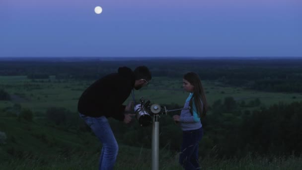 Padre e sua figlia guardano attraverso un telescopio la luna — Video Stock