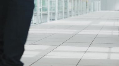 Modern bir havaalanı terminalinde yürüyen bir çanta ile Adam