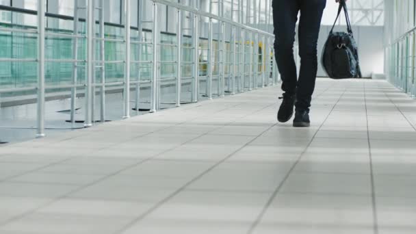 ein junger Mann mit Handtasche in einem modernen Flughafenterminal
