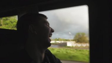 Turist adam otobüsle seyahat ediyor. Otobüs penceresinden bakar