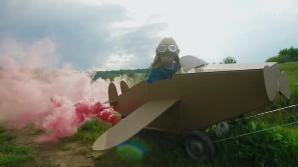 Far och son leker med kartong flygplan på dagtid — Stockvideo