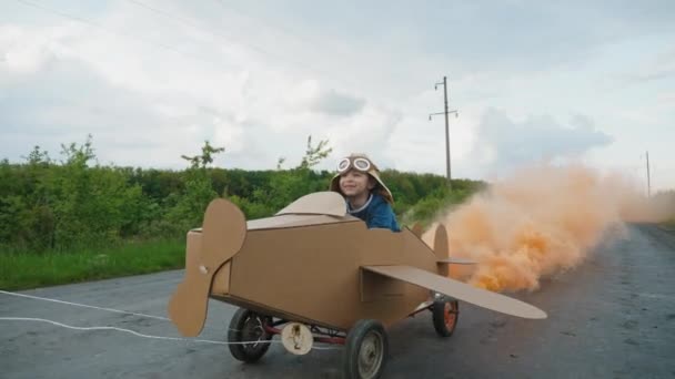 Père roule son fils sur un avion en carton fait maison — Video