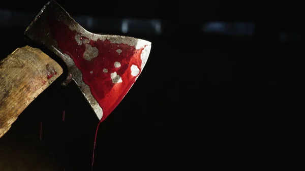 Axe with blood in hand on the dark background — Stock Photo, Image