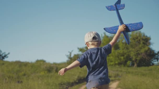 Un ragazzo con un aeroplano in mano corre nel parco — Video Stock