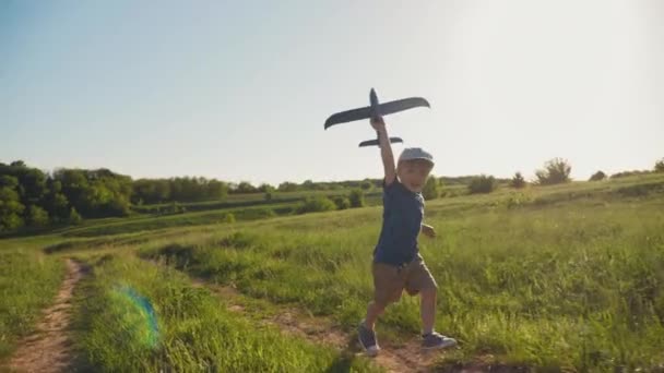 Ребенок с самолетом бежит в природе — стоковое видео