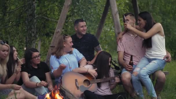 Amigos alrededor de una hoguera ardiendo en el bosque — Vídeos de Stock