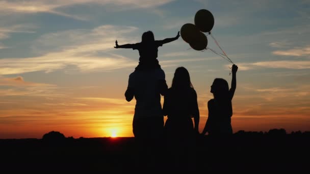 Familie met ballonnen bij zonsondergang — Stockvideo