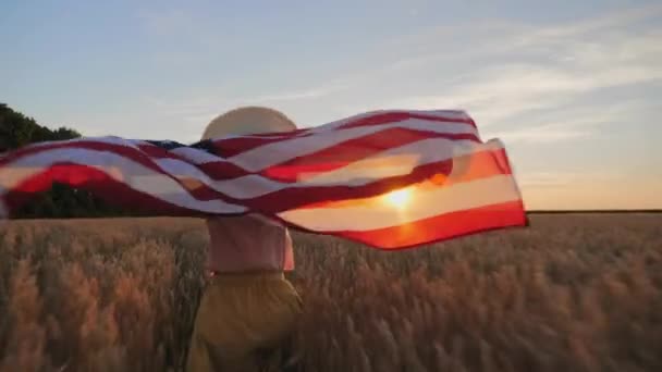 Жінка біжить з прапором Америки в полі — стокове відео