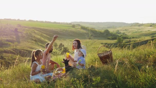 Šťastná rodina na pikniku s miniaturní Pinscherem — Stock video