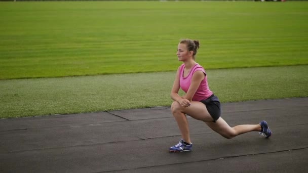 Atletisk flicka gör utfall börja upp på Stadium — Stockvideo