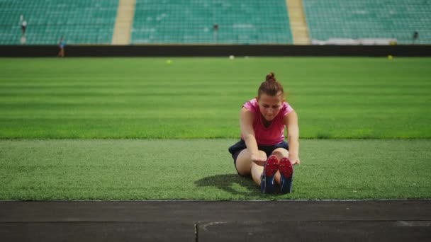 Atletische meisje doet oefeningen in het stadion — Stockvideo