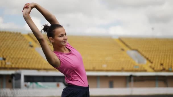 Atletická dívka roztáhne ruce a couje před spuštěním — Stock video