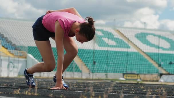 Het meisje begint de Sprint op de baan — Stockvideo