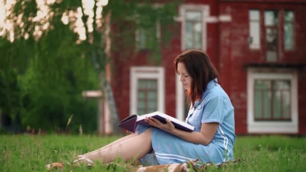 Жінка читає книгу в парку, крупним планом — стокове відео