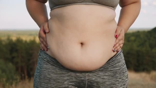 A menina com sobrepeso balança sua barriga gorda — Vídeo de Stock