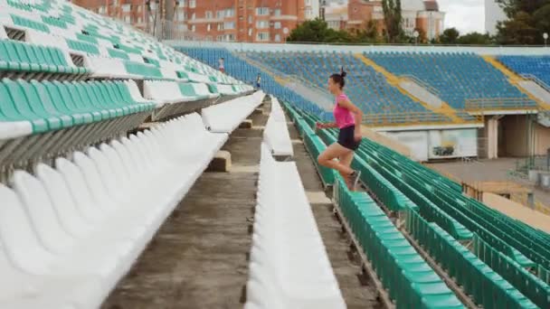 Oldalnézetből egy lány fut az emeleten a stadion — Stock videók