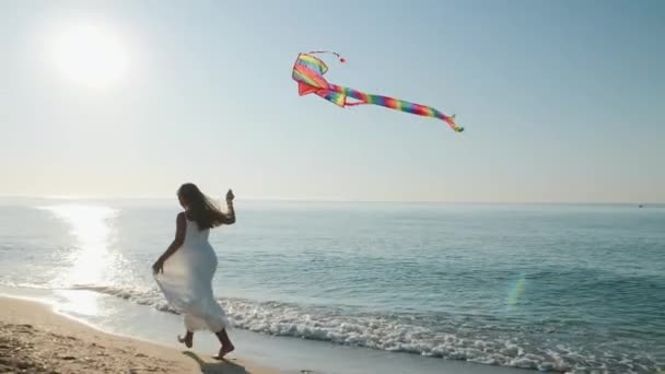 Teen girl runs with a kite along the seashore — Stock Video