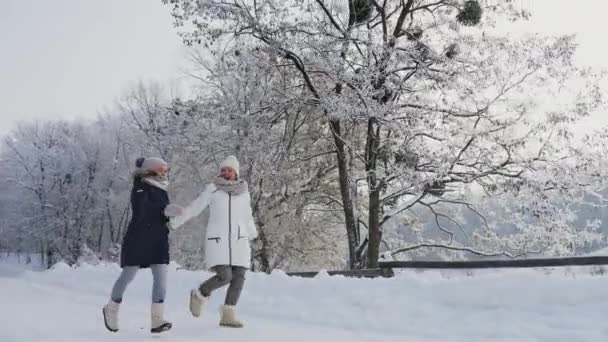 Μαμά με την κόρη τρέχει σε ένα χιονισμένο δρόμο — Αρχείο Βίντεο