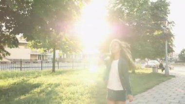 Çocuk güneşli bir günde akıllı telefonla yürüyor