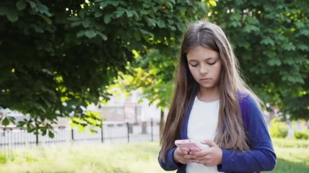 Dziecko spacerów ze smartfonem w słoneczny dzień — Wideo stockowe