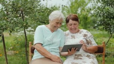 Yaşlı kadınlar dışarıda dijital tablet kullanıyor