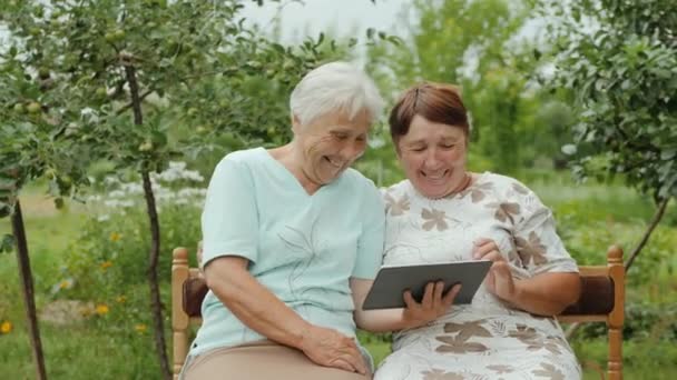 Οι ηλικιωμένες γυναίκες χρησιμοποιούν ένα ψηφιακό δισκίο σε εξωτερικούς χώρους — Αρχείο Βίντεο