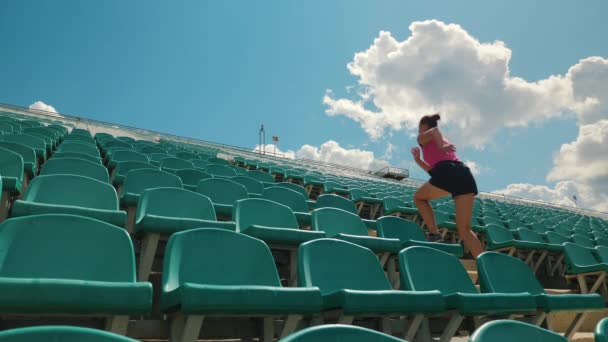 Mädchen läuft in einem Stadion die Treppe hinauf — Stockvideo
