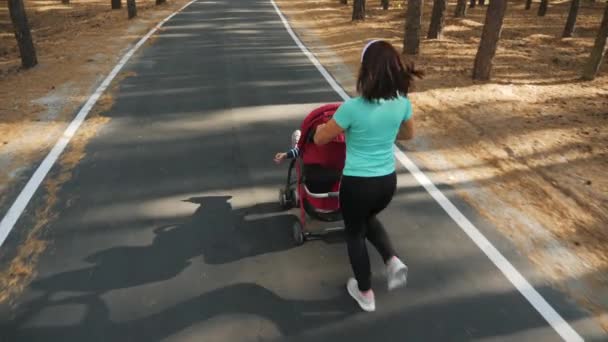 Ansicht von oben: Laufende Frau mit Kinderwagen — Stockvideo