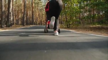 Geri görünüm: Ormanda bebek arabası ile çalışan kadın