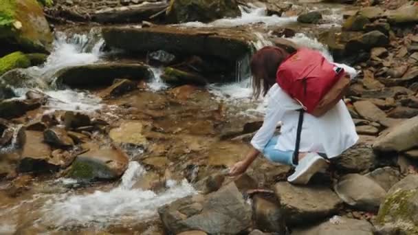 Kadın, akan nehrin su akıntısına dokunuyor — Stok video