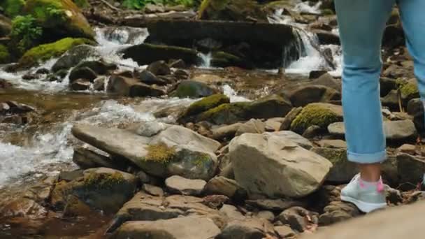 Gambe femminili attraversano il fiume di montagna — Video Stock